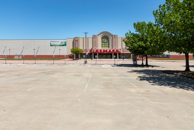 Park by buildings against clear blue sky