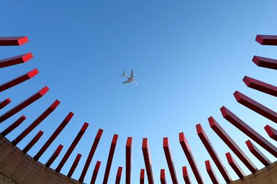 Low angle view of airplane flying in clear blue sky