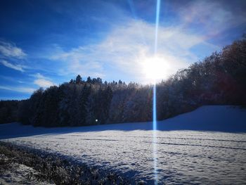 Scenic view of snow covered land against bright sky