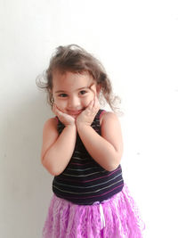 Portrait of smiling girl standing against white background