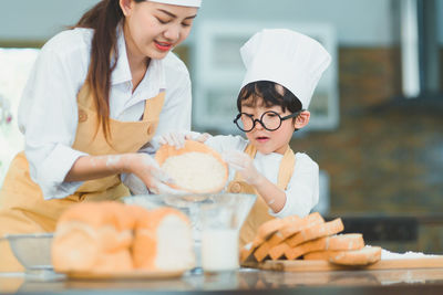 Full length of mother and daughter on table