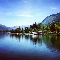 Scenic view of lake and mountains against blue sky