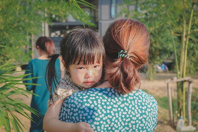 Rear view of woman and girl looking at camera