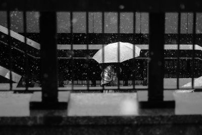 Buildings seen through wet railing during winter