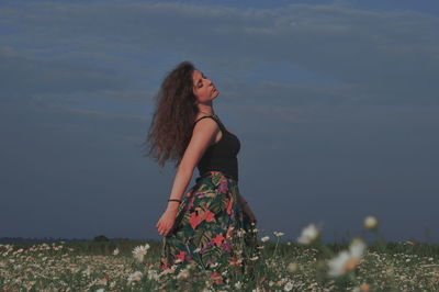 Woman standing on field against sky