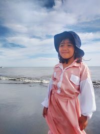 Full length of woman standing on beach against sky