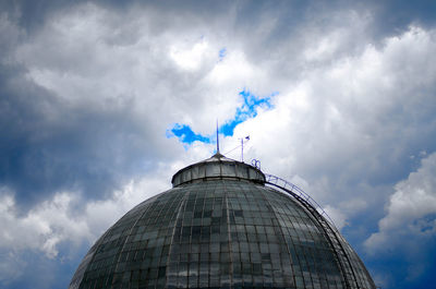 Low angle view of dome against cloudy sky