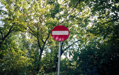 Low angle view of road sign against trees