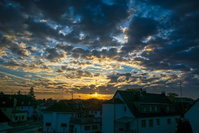 Houses against sky during sunset