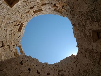 Low angle view of old ruin seen through hole