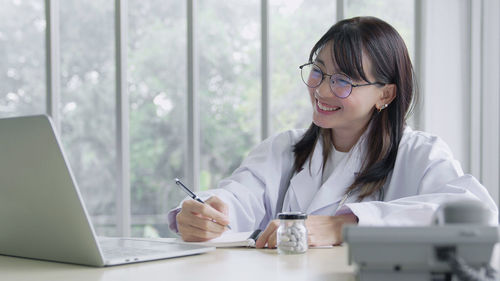 Asia woman doctor consulting patient with sickness symptoms online via video call on laptop 