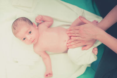 High angle of adult massaging baby