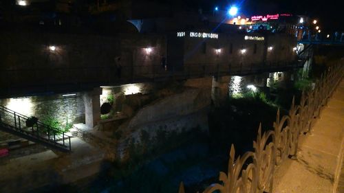 Illuminated bridge over water at night
