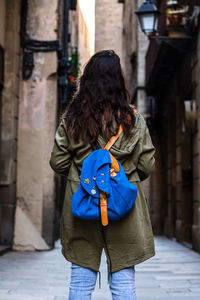 Rear view of woman with umbrella walking in snow