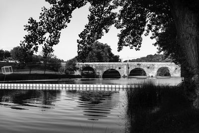 Low angle view of arch bridge over river against sky