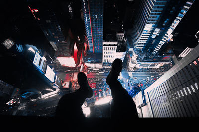 People in illuminated city against sky at night