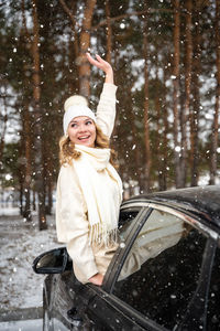 Portrait of young woman holding car