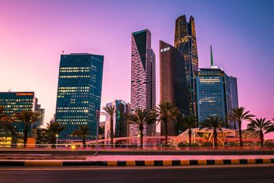 Modern buildings in city against sky at night