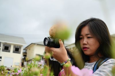 Portrait of woman photographing with camera