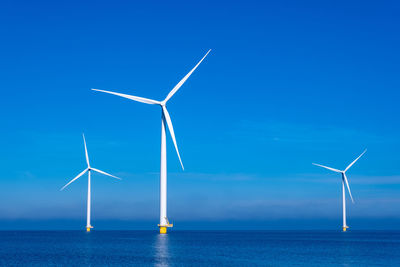 Wind turbines against blue sky