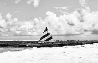 Sailboat sailing on sea against sky