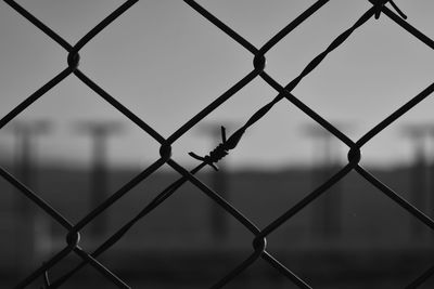 Close-up of chainlink fence against sky