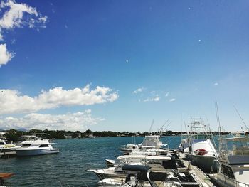 Boats moored on sea against blue sky