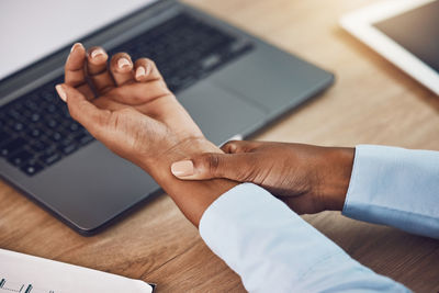 Cropped hands using laptop on table