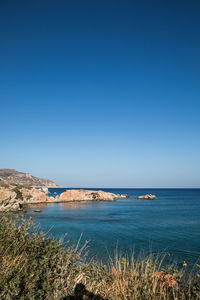Scenic view of bay against clear blue sky