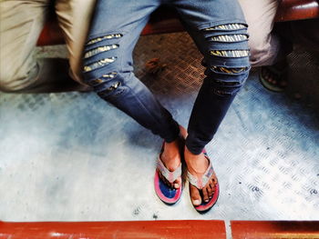 Low section of people standing on tiled floor