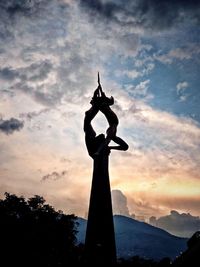 Low angle view of statue against cloudy sky