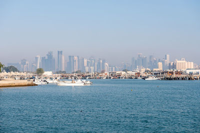 Panoramic view of sea and cityscape against clear sky