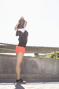 Full length of woman doing warm up exercises on bridge