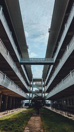 Low angle view of bridge amidst buildings against sky