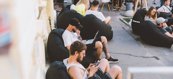 High angle view of people sitting on street in city