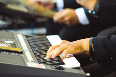 Midsection of man playing piano