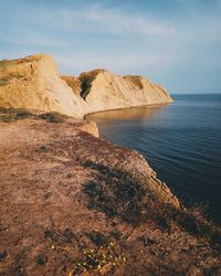 Rock formation by sea against sky