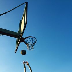 Low angle view of basketball hoop against blue sky