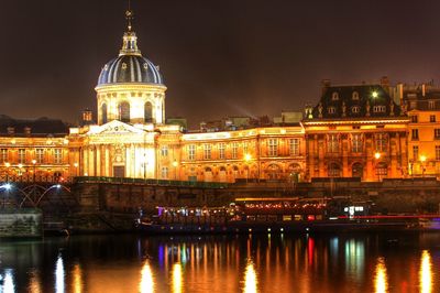 Illuminated institut de france by river against sky in city at night