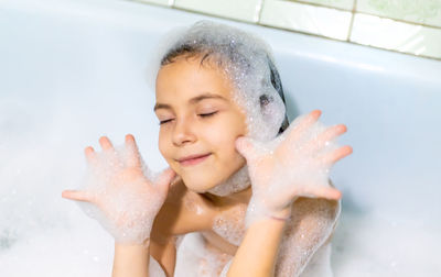 Portrait of young woman washing hands in bathroom