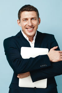 Portrait of young man standing against white background