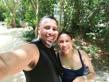 Portrait of happy friends against trees