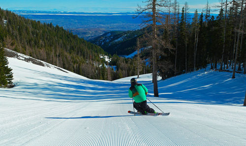 Rear view of woman skiing on snow landscape