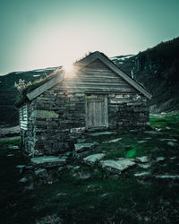 Abandoned house on field against sky