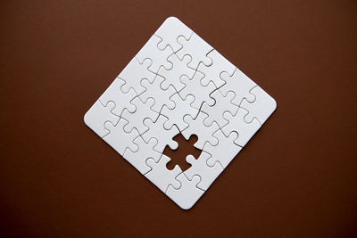 Close-up of white jigsaw pieces on table