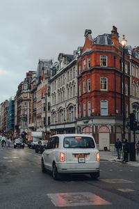 Cars on street amidst buildings in city