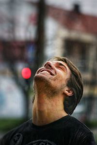 Close-up of cheerful young man standing outdoors