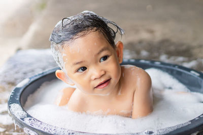 Cute baby girl sitting in tub