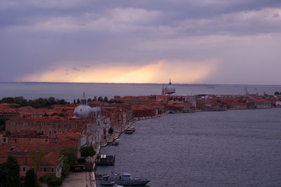 High angle view of buildings by sea against sky