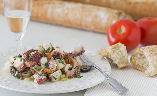 Octopus bread, tomatoes and a glass of white wine.